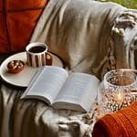 cozy autumn reading corner with blanket and mug